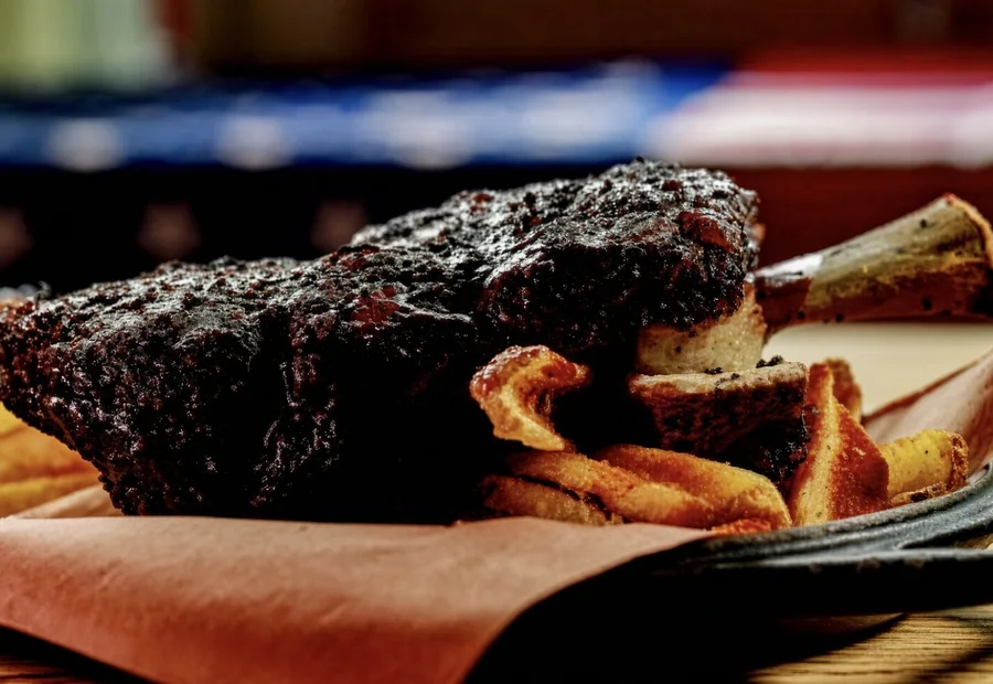 A Henry’s smoked beef rib with a dark crust, plated with sides